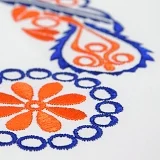 Detail hladkovanej folklórnej výšivky na hrudi chlapčenskej košele