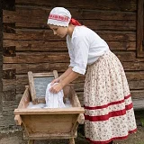 Slovenská žena perie prádlo v drevenom koryte